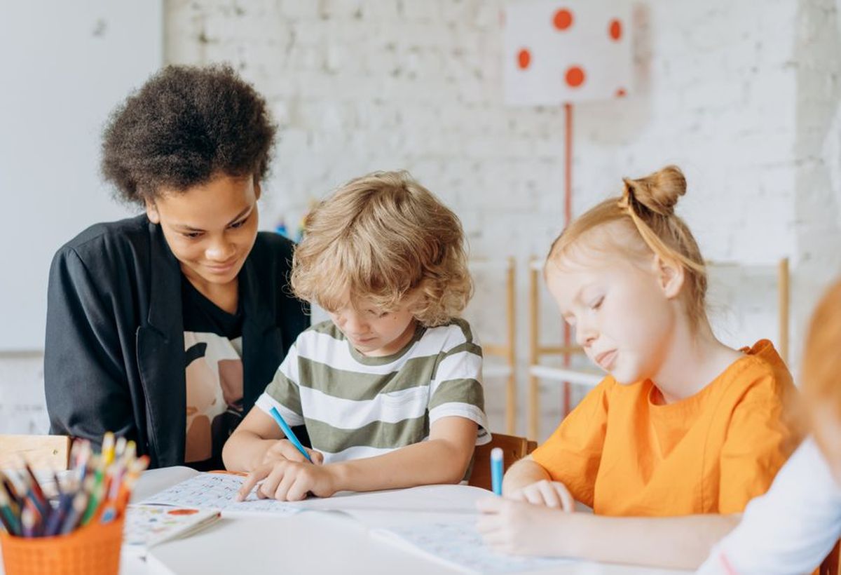 A teacher working with two children