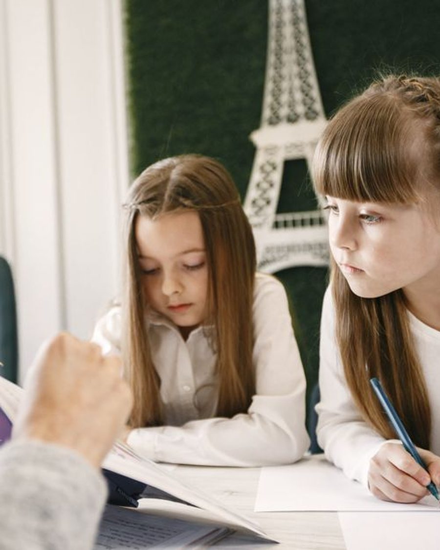 A teacher working with two students